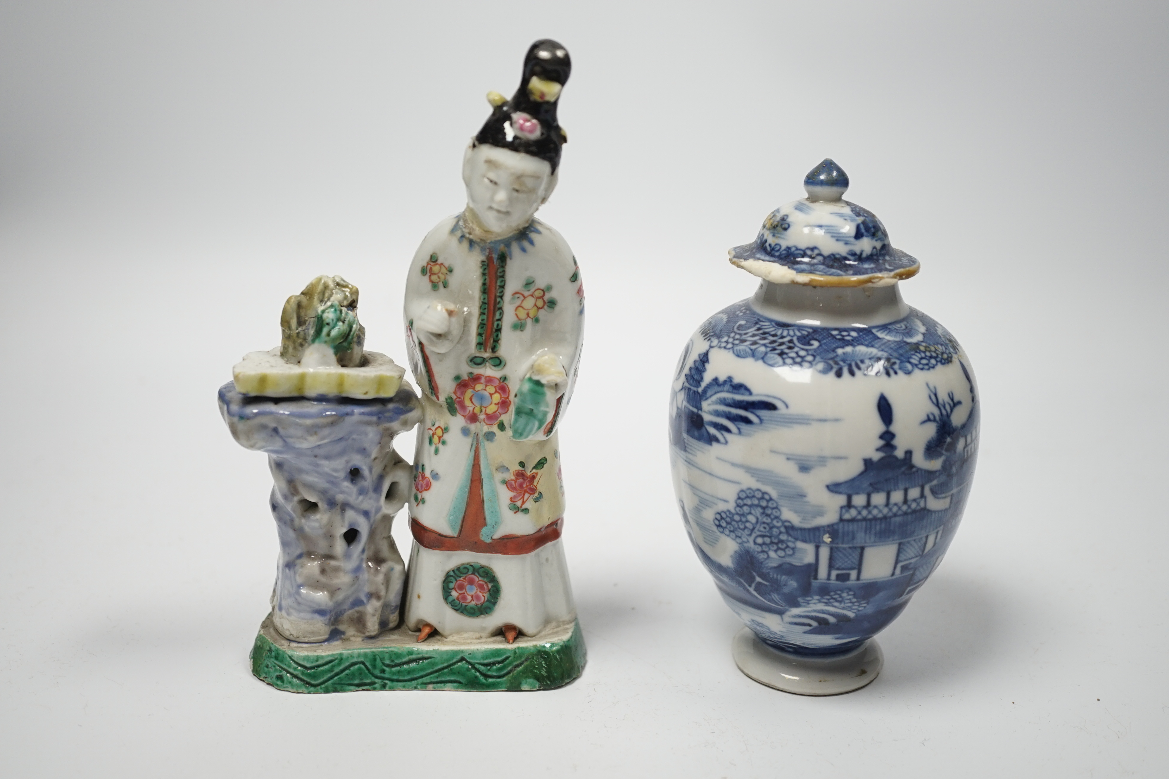 An 18th century Chinese enamelled porcelain figure of a lady standing by rockwork, a similar miniature vase and a blue and white tea caddy and cover, largest 17cm high